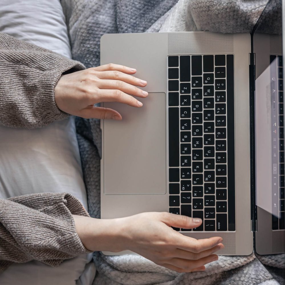 a-woman-working-on-a-laptop-while-lying-in-bed-to-2022-04-01-06-38-16-utc.jpg